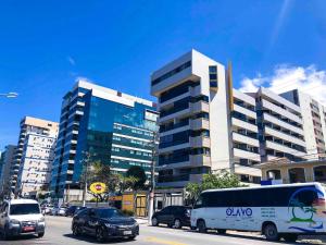 una calle de la ciudad con coches y un autobús delante de un edificio en TENERIFE - 107 · T-07: Beira mar da Pajuçara Piscinas Naturais, en Maceió