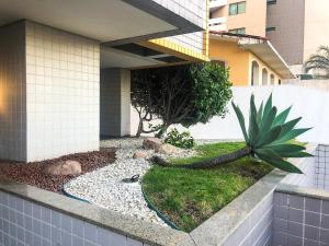 Un patio con una planta y un edificio. en TENERIFE - 107 · T-07: Beira mar da Pajuçara Piscinas Naturais, en Maceió