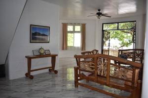 a living room with two chairs and a table at Seaside traveler's Inn by Camiguin Island Home in Catarman +26 photos