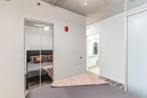 a bedroom with white walls and a bed with a mirror at DT Delight Downtown Living One-bedroom Endless Access in Cleveland +5 photos