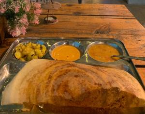 a tray of food with a turkey and three dipping sauces at The Kashi Baba Homestay in Dharamshala