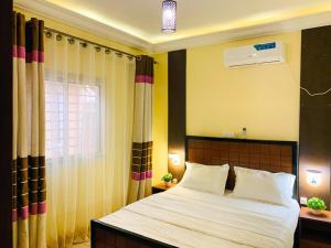 a bedroom with a large bed and a window at Residence OKEO in Yaoundé