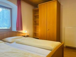 a bedroom with two beds and a wooden cabinet at Apartments Bernard in Aldino
