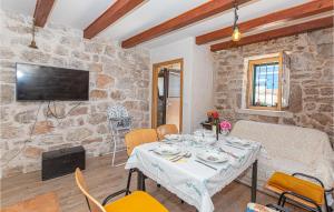 a dining room with a table and a stone wall at Awesome Home In Kaprije With Wifi in Kaprije