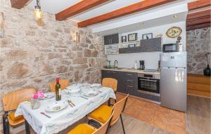 a kitchen and dining room with a table and a refrigerator at Awesome Home In Kaprije With Wifi in Kaprije