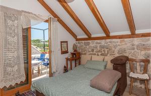 a bedroom with a bed and a stone wall at Awesome Home In Kaprije With Wifi in Kaprije +14 photos