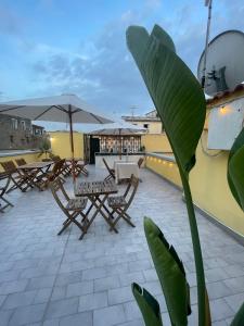 patio ze stołami i parasolami na dachu w obiekcie 4heavens_naples w mieście Neapol
