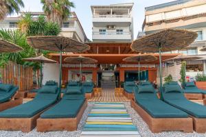 a resort with blue chairs and umbrellas at Vila e Bardhe Butique Hotel in Sarandë