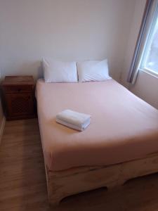 a bed with a white towel on top of it at Lepihue in Puerto Montt