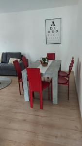 ポラントリュイにあるAppartement meubléのダイニングルーム(テーブル、赤い椅子付)