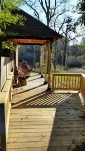 a wooden porch with a bench on top of it at Sunflower Cottage on the River in Clarksdale +31 photos