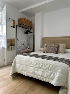 a bedroom with a large bed with two mirrors at Apartamentos La Hormiga Deluxe in Adra