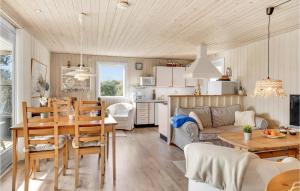 a kitchen and living room with a table and chairs at Lovely Home In Juelsminde With Kitchen in Sønderby