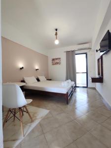 a bedroom with a bed and a table and a chair at Creta Star Apartments in Agia Galini +34 photos