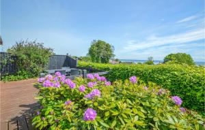 a bush with purple flowers on a patio at Holiday Home Binderup Strandpark Bjert Denmark in Sønder Bjert