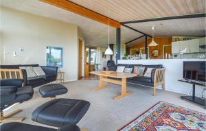 a living room with a couch and a table and chairs at Holiday Home Binderup Strandpark Bjert Denmark in Sønder Bjert