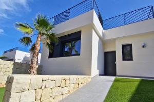a white house with a palm tree in front of it at Villa SolyMar in Polop Hills Luxury and comfort ! in Polop