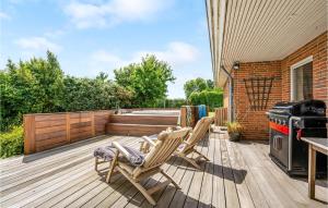 哈泽斯莱乌Beautiful Home In Haderslev With Wifi的木制甲板配有两把椅子和炉灶