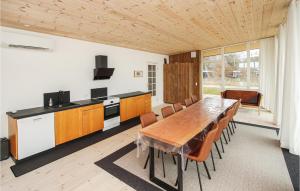 NordbyにあるCozy Home In Samsø With Wifiのキッチン(長い木製テーブル、椅子付)