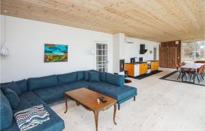 NordbyにあるCozy Home In Samsø With Wifiの青いソファとテーブルのあるリビングルーム
