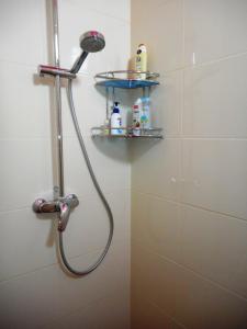 a shower with a shower head and shelves in a bathroom at Hostel Q ,15 хв до жд вокзалу in Lviv +21 photos