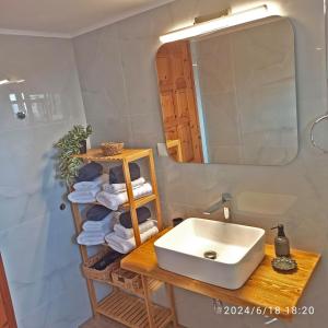 a bathroom with a sink and a mirror and towels at Geothan's House in Skala Sotiros +17 photos
