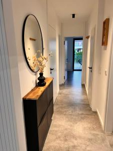 a hallway with a large mirror and a dresser at Neubau Luxus 2 Zimmer Apartment in Mönchengladbach