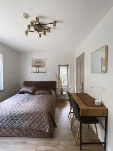 a bedroom with a bed and a table and a desk at Nidos Baltija in Nida