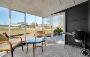 una stanza con tavolo, sedie e griglia di 3 Bedroom Awesome Home In Thisted a Thisted