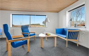 un soggiorno con tavolo e sedie blu di 3 Bedroom Awesome Home In Thisted a Thisted
