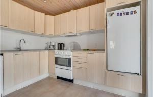 una cucina con mobili in legno e un frigorifero bianco di 3 Bedroom Awesome Home In Thisted a Thisted