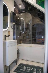 a bathroom with a tub and a sink and mirror at Apartments Mehić in Mostar +23 photos