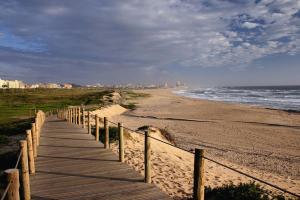 a wooden path leading to a beach with the ocean at Hotel Apartamento Solverde in Espinho