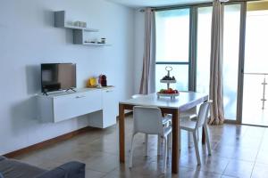 a kitchen and dining room with a table and chairs at Duarte Apartments - Las Rochas in Mindelo