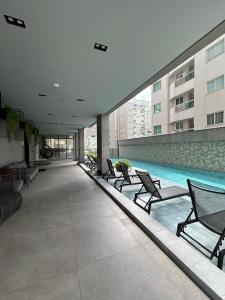 a building with a swimming pool with chairs next to a building at Flat 1609 Infinity Tower in Itapema