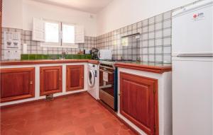 a kitchen with wooden cabinets and a stove top oven at Nice Home In Marbella in Marbella