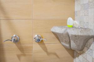 a bathroom with two knobs on a wall at Casa Noble Hotel in Antigua Guatemala
