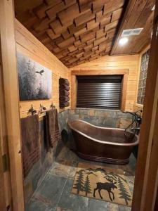 a large wooden bathroom with a tub and a sink at Moose Lodge in Ashton