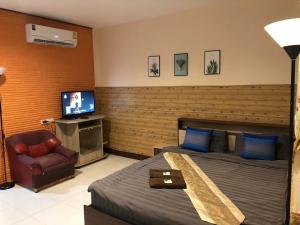 a hotel room with a bed and a television at Sandee Place Mountain View Bed&Breakfast in Chom Thong