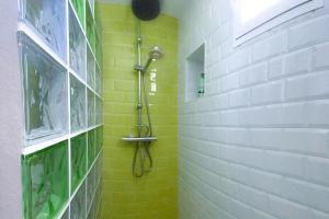 La salle de bains est pourvue d'une douche et d'un mur jaune. dans l'établissement Sanlúcarsun Apartamento en el centro, à Sanlúcar de Barrameda 9 autres photos