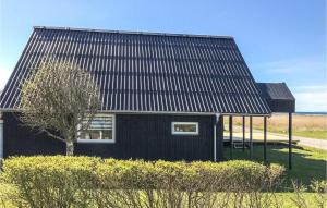 ein schwarzes Haus mit einem Baum davor in der Unterkunft Two-Bedroom Holiday Home In Knebel in Knebel + 19 Fotos