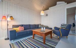 ein Wohnzimmer mit einem blauen Sofa und einem Tisch in der Unterkunft Two-Bedroom Holiday Home In Knebel in Knebel