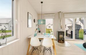 a kitchen with a table and two white chairs at Sea You in Olpenitz +26 photos