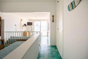 a room with a staircase and green tile floors at A Window to the Sea in Nettuno +18 photos
