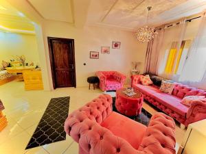a living room with a red couch and chairs at Dar La Madina Essaouira in Essaouira