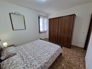 a bedroom with a bed and a wooden cabinet at Appartamento Dune in Santa Lucia