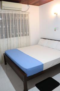 a bedroom with a bed in a room with a window at Dream Villa - Weligama in Weligama