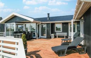 a house with a deck with chairs on it at Pet Friendly Home In Hvide Sande in Hvide Sande