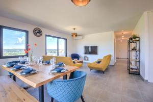 a dining room and living room with a table and chairs at Sunset villa in Trélissac