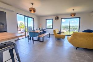 a living room with a table and chairs and windows at Sunset villa in Trélissac